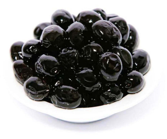 Bowl of black olives in natural state on white background