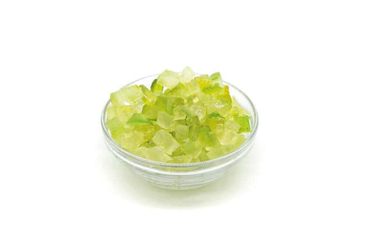 Bowl of candied green papaya cubes against a white background