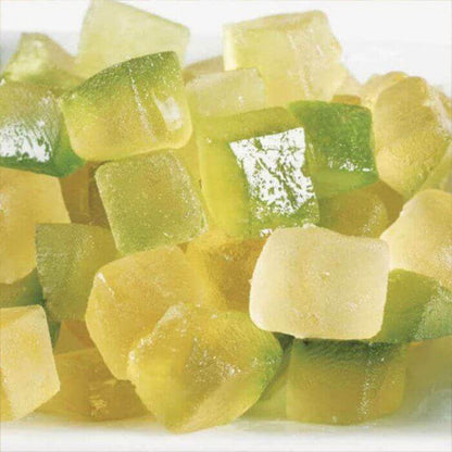 Assorted yellow and green candied fruit chunks on a white plate